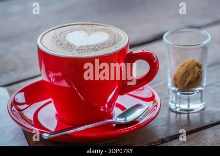 Herzhafter Latte Art heißer Kaffee auf dem Holztisch als Liebeskonzept Stockfoto