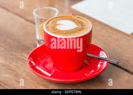 Herzhafter Latte Art heißer Kaffee auf dem Holztisch als Liebeskonzept Stockfoto