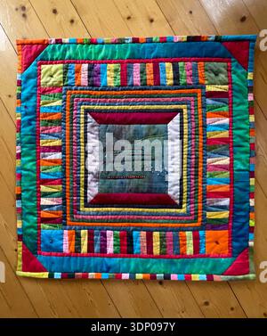 Um ein Stickmuster wuchs eine Wand hängende Decke, die diese Studie in eine fröhliche Explosion von Farben, Texturen und genähten Linien verwandelte. Stockfoto