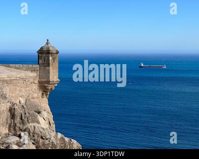 Küstenburg Santa Bárbara über dem Mittelmeer mit einem Schiff unter blauem Himmel, Alicante, Valencianische Gemeinschaft, Spanien, März 2024 Stockfoto