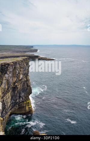 Malerischer Blick auf die irische Küste mit zerklüfteten Klippen mit Blick auf den riesigen Atlantik unter einem bewölkten Himmel. Stockfoto