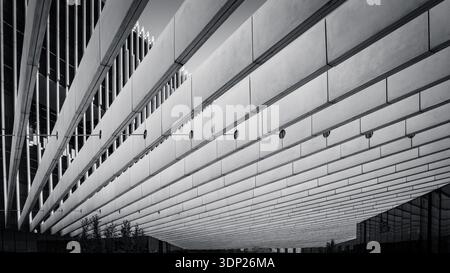 Beeindruckendes architektonisches Design, das aus einer faszinierenden Perspektive aus einem niedrigen Winkel erfasst wird. Das Bild zeigt eine Reihe paralleler Betonbalken in Lissabon Stockfoto