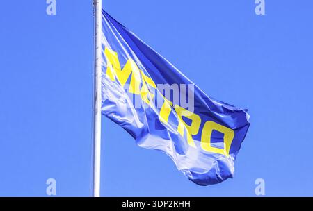 Samara, Russland - 25. Juni 2022: Flagge mit Logo der Metro Group flattert auf dem Wind gegen den blauen Himmel. Die Metro Group ist ein deutscher Vertriebskonzern Stockfoto