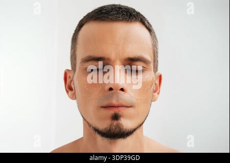 Männliches Gesicht mit feuchtigkeitsspendenden Augenflecken. Stockfoto