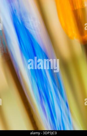 Ein Blitz von elektrischem Blau reißt diagonal durch ein Feld aus geschmolzenem Orange und Bernstein wie ein Blitz, das altes Harz spaltet. Diese auffällige ICM-Abstra... Stockfoto