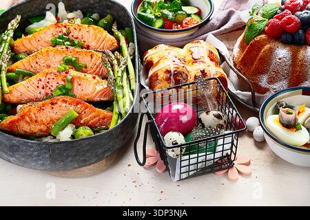 Im Ofen gebratener Lachs mit grünen Bohnen und Spargel zum Osterbrunch oder Abendessen auf hellem Hintergrund. Draufsicht. Stockfoto
