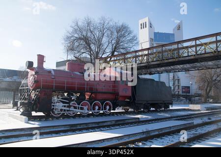 Im Winter parkt am Bahnhof Chisanau eine Dampfeisenbahn, die den Boden bedeckt und die Gebäude der Stadt sichtbar macht. Stockfoto