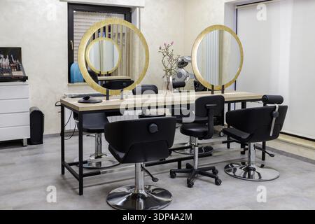 Leere, moderne Innenausstattung des Friseursalons in goldenen und grauen Farben. Stockfoto