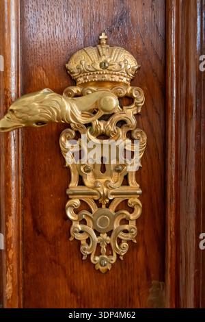 Nahaufnahme eines vergoldeten barocken Türgriffs an einer Holztür der Österreichischen Nationalbibliothek Stockfoto