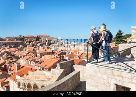 Touristen blicken in die Morgensonne über die Altstadt von Dubrovnik von einem Aussichtspunkt auf der Stadtmauer der Festung Minceta Stockfoto