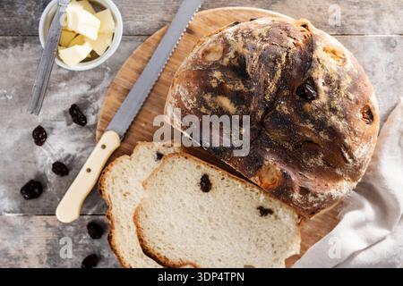 Traditionelles irisches Soda-Brot mit Rosinen, frisch gebacken und in Scheiben geschnitten auf Holztisch Stockfoto
