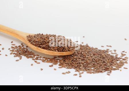 Leinsamen in Holzlöffel auf weißem Hintergrund Stockfoto
