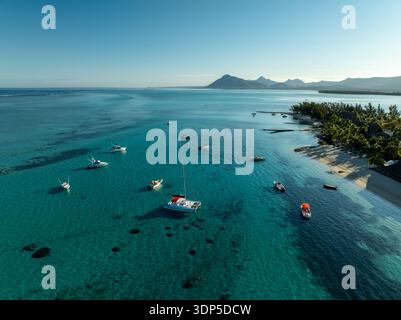 Aus der Vogelperspektive auf dem türkisfarbenen Wasser in der Nähe der üppigen, grünen Küste mit dem Berg Le Morne Brabant in der Ferne, Le Morne, Rivière Noir Stockfoto