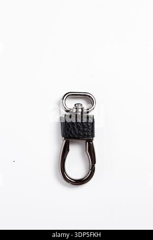 Eleganter Schlüsselanhänger aus schwarzem Leder und Metall mit Karabiner auf weiß, perfekt für Taschen, Schlüssel und Alltagsaccessoires. Stockfoto