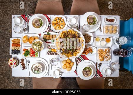 Ein sorgfältig arrangiertes Bankett mit Samosas, Plov und diversen Beilagen, perfekt für die Veranstaltungsplanung. Stockfoto