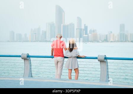 Kaukasische Touristen romantische Paare stehen zusammen und genießen das Panorama der Skyline auf dem malerischen Aussichtspunkt in Abu dhabi. Besuchen Sie die Reise Sightseeing VAE Concept Stockfoto