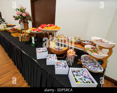Farbenfroher Buffettisch mit frischem Obst, Gebäck und verschiedenen Süßigkeiten für Veranstaltungen oder Partys Stockfoto