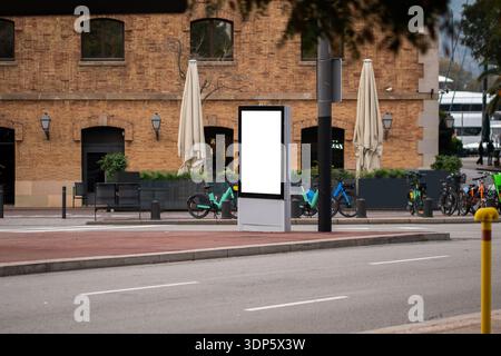 Leeres vertikales, digitales Reklametafelmodell, das auf der Stadtstraße in der Nähe von Fahrrädern steht Stockfoto