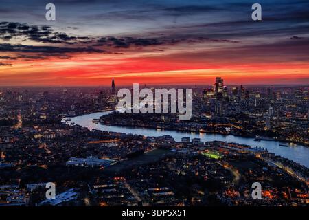 Breiter Panoramablick auf die städtische Skyline von London City entlang der Themse bei einem farbenfrohen Sonnenuntergang mit roten und orangen Wolken, England Stockfoto