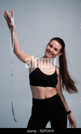 Glückliche junge Frau in Sportkleidung lächelt in die Kamera Stockfoto