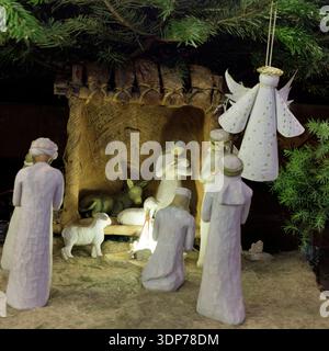 Handgefertigte Krippenfiguren Unter Immergrünen Zweigen, Rustikale Weihnachtsdekoration Stockfoto