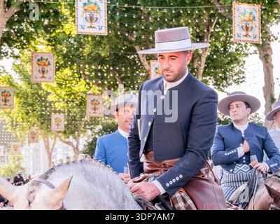 Spanischer Reiter in traditioneller Kleidung zu Pferd bei einer Outdoor-Kulturveranstaltung. Stockfoto