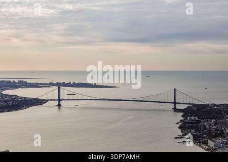Blick aus der Vogelperspektive nach Süden über die Verrazzano-Narrows Bridge und die Upper New York Bay in Richtung Atlantik, mit Frachtschiffen und dem Staten IS Stockfoto