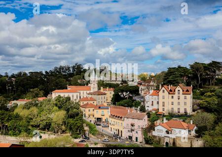 Blick aus der Vogelperspektive auf Sintra, Portugal, mit Terrakottadächern, üppigem Grün und einem dekorativen Turm. Stockfoto