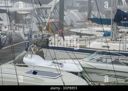 Nahaufnahme von Yachten und Motorbooten im Hafen von Yarmouth bei dichtem Nebel oder dichtem Nebel an einem Wintertag. Stockfoto