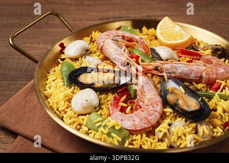 Paella mit Meeresfrüchten, in einer Pfanne, auf einem Holztisch, keine Leute Stockfoto