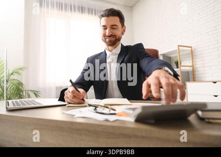 Ein Buchhalter, der im Amt Berechnungen macht Stockfoto