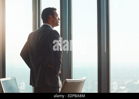 Fenster, Mitarbeiter und Mann im Amt, denken und Ideen für die Karriereentwicklung, ernsthaft oder nachdenklich. Unternehmen, Person und Plan für Geschäftswachstum Stockfoto