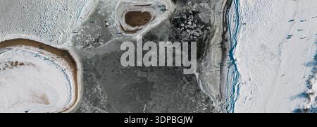 Abstrakte Winter Land Luftauflösung. Draufsicht Polen Europa zeigt gefrorene Küstenformen, organische Eisformationen und kontrastierende dunkle Wassertöne Stockfoto