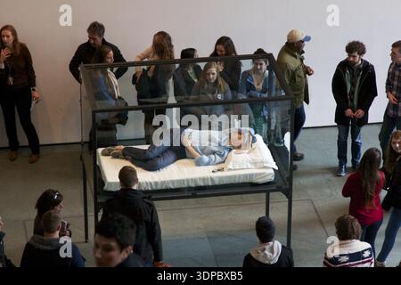 23. MÄRZ 2013: NEW YORK, NY, USA: Besucher des Museum of Modern Art (MoMA) sehen, wie die Hollywood-Star Tilda Swinton in einer Glasbox für ihre Ar schläft Stockfoto