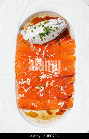 Lachsscheiben mit cremiger Sauce und Kräutern Stockfoto