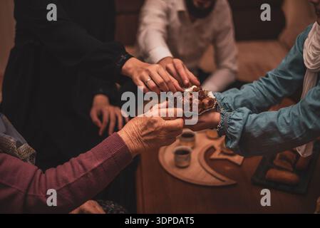 Daten während der Ramadan-Feier aus nächster Nähe: Mitglieder der muslimischen Generation, die während des Iftar traditionelle Speisen genießen Stockfoto