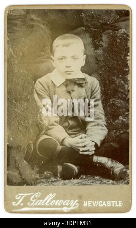 1880er Jahre ernsthafter viktorianischer Junge gespenstisches Bild, viktorianisches Kind trägt Anzug, Stiefel. Viktorianische Kinder. Von T. (Thomas) Galloway, Newcastle, Großbritannien um 1880er Stockfoto