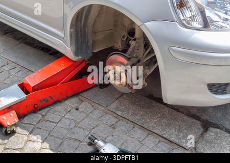 Austausch beschädigter Autoreifen während der Straßenwartung Stockfoto