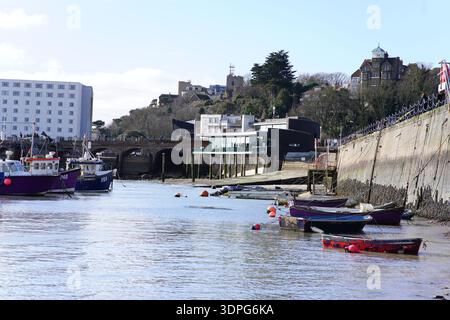 Farbenfrohe Fischerboote bei Ebbe im Hafen von Folkestone mit Grand Burstin Hotel und Promenade. Folkestone, England Stockfoto