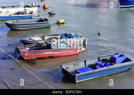 Verwitterte kleine Boote, die bei Ebbe im Hafen von Folkestone mit Angelausrüstung und Bojen geerdet sind. Folkestone, England Stockfoto