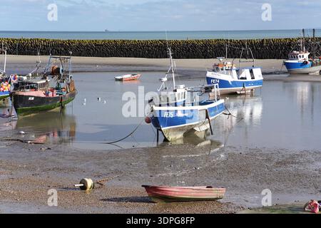 Farbenfrohe Fischerboote bei Ebbe am schlammigen Folkestone Beach, blaue Rümpfe und Reflexionen, Wellenbrecher und ruhiges Meer, Kent England Küste. Stockfoto