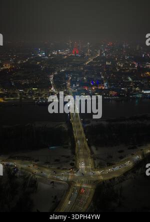 Die Nachtszene in Warschau zeigt die Swietokrzyski-Brücke über die Weichsel, leichte Wege auf verschneiten Straßen und den Palast der Kultur und Wissenschaft Stockfoto
