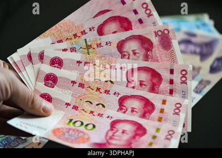 China. Februar 2026. In dieser Fotoabbildung fächert eine Hand einen Stapel 100-Yuan-RMB-Banknoten auf und zeigt mehrere Porträts und Sicherheitsmerkmale vor dunklem Hintergrund. Der chinesische Yuan hat in den letzten Perioden leichte Schwankungen gegenüber dem US-Dollar erlebt, wobei der allgemeine Trend einer moderaten Aufwertung zu verzeichnen war. Quelle: SOPA Images Limited/Alamy Live News Stockfoto