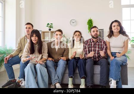 Freunde, die angespannte Fußballspiele zu Hause im Fernsehen sehen, ängstliche Fans auf dem Sofa Stockfoto