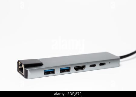 Nahaufnahme des silbernen USB-C-Hubs mit RJ45 HDMI- und USB-A-Anschlüssen auf weißem Hintergrund. Stockfoto