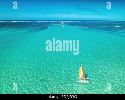 Lebhaftes Türkisfarbenes Meer Mit Kleinem Segelboot Unter Klarem Blauen Himmel Über Der Karibik, Punta Cana, Dominikanische Republik Stockfoto