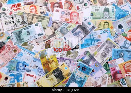 Viele Banknoten unterschiedlicher Währung. Eine große Menge von zufälligen Geldrechnungen aus der Nähe. Währungsumtausch-Konzept Stockfoto