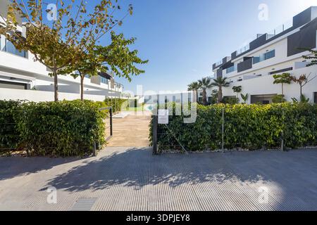 Sonniger Blick auf die modernen Apartmentgebäude, die einen Landschaftsgarten und einen gemeinsamen Swimmingpool umgeben, in einem modernen Wohngebäude. Stockfoto