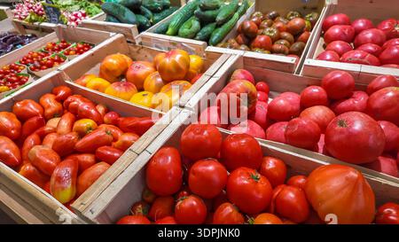 Vielfalt von Erbtomaten und Gurken in Holzkisten Stockfoto