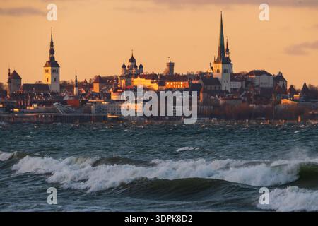 Dramatischer Panoramablick auf die Skyline der Altstadt von Tallinn von der Ostsee mit stürmischen Wellen und mittelalterlichen Kirchtürmen. Stockfoto
